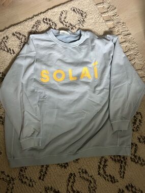 SOLÁI Women's Light Blue Crewneck Sweatshirt with Yellow Logo